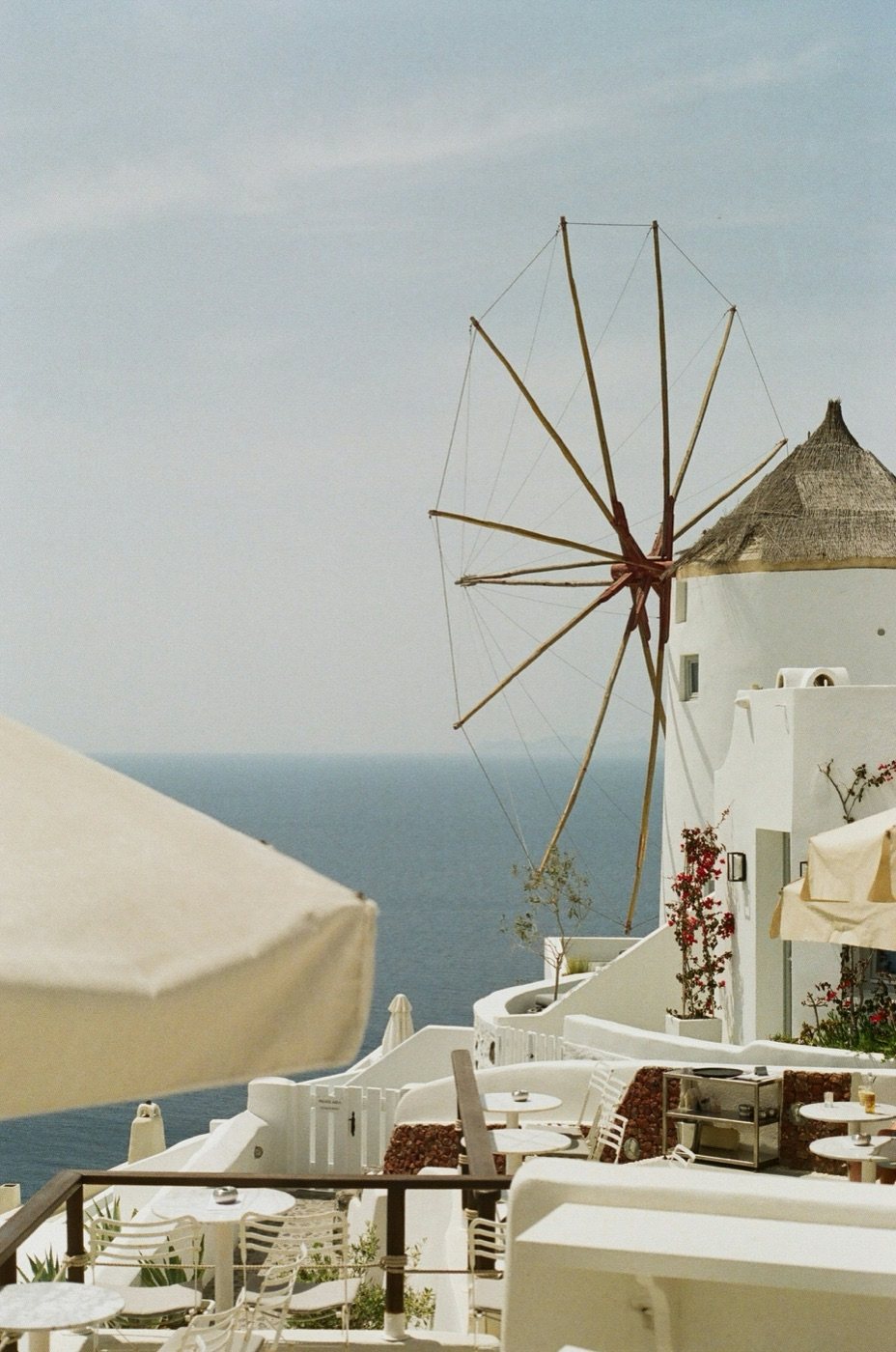 Santorini windmill and whitewashed terrace above the Aegean Sea